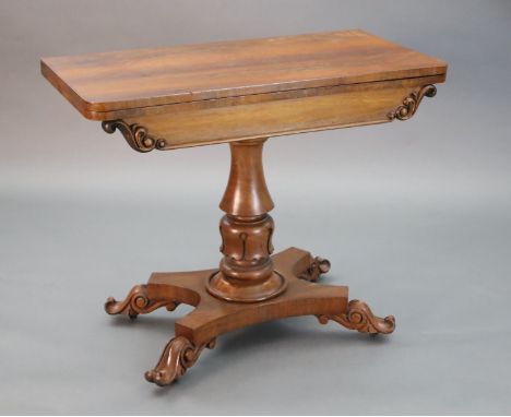 A William IV faded rosewood folding card table, with D shaped folding top, on turned and carved stem with saltire stretcher, 