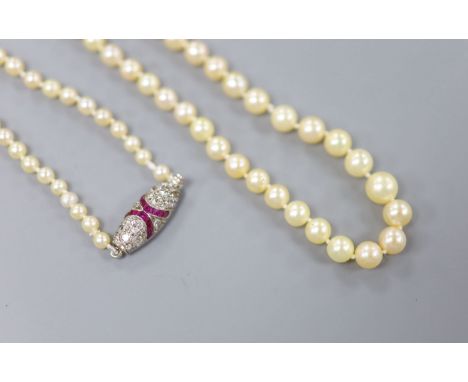 An early 20th century single strand graduated seed pearl necklace, with white metal ruby and diamond set clasp, 44cm, gross w
