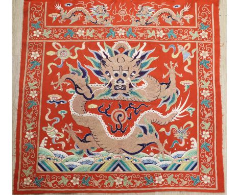 A early 20th century Chinese red felt square panel embroidered with a central motif of a dragon, width 86cm height 84cm