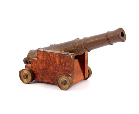 Old model of a 17th century naval cannon, with a brass cannon barrel and a wooden gun carriage, barrel length 20 cm