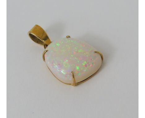 A fine white opal pendant, the free form stone set into a simple four claw setting, 2.5cm long including bale, marked '18k', 