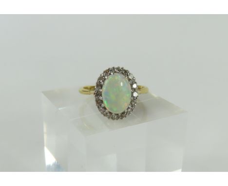 An early to mid-20th century fine white opal and diamond cluster ring, the oval cabochon cut opal with a row of small diamond