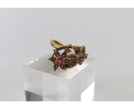 A 9ct gold ruby set dress ring, the rubies set into to two flower shapes, finger size M, 4.92g gross, in associated case