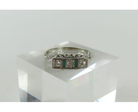 A 20th century (first half) diamond ring, the pierced setting with decorative scrolled shoulders, the three round shaped diam