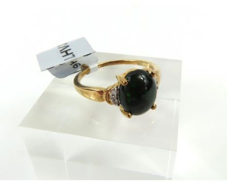 A 9ct gold black opal and white stone dress ring, the oval cabochon cut opal in a four claw setting, finger size N1/2, 2.44g 