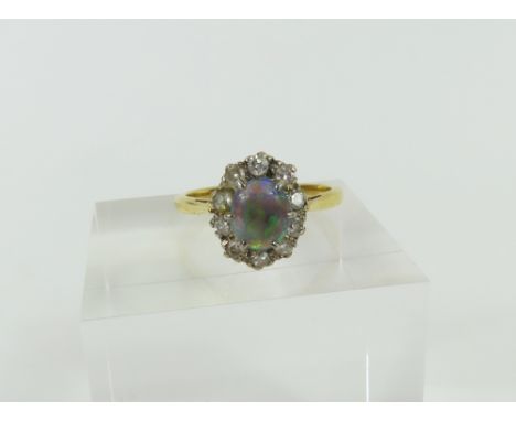 A 20th century black opal and diamond cluster ring, the oval cabochon cut opal in a six claw setting, with a row of eight cut