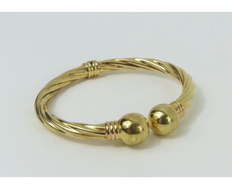 A hinged gold torque bangle, of usual form, with twisted bars, marked '375', 11.42g gross
