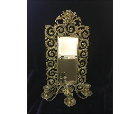 A Brass mirror backed three prong candle stick.