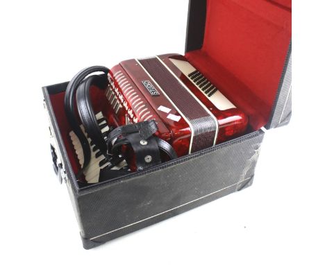 A Studio accordion. With marbled red case, within a fitted travelling box, L40cm