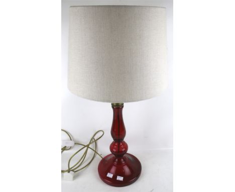 A contemporary ruby glass table lamp. With gilt details around the rim and a cream fabric shade, H44.5cm (excluding fittings)