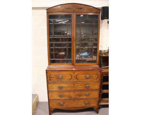 A Regency mahogany secretaire bookcase. The base with four long drawers, the top falling forward and withdrawing to reveal pi