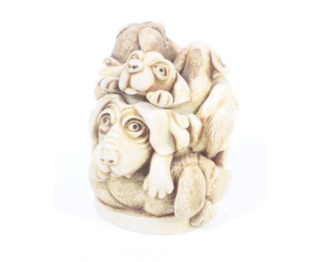 A resin pot modelled as various dogs. Possibly a netsuke, H5cm