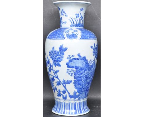 A large early 20th century blue and white Chinese oriental ceramic porcelain vase of a baluster form being decorated with flo