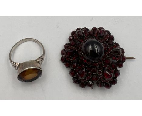 A silver dress ring set with cut stone size R together with a red gem set brooch 4mm diameter. 