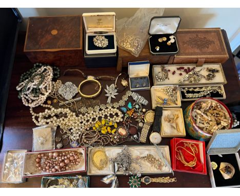 A large quantity of vintage costume jewellery to include brooches, watches, necklaces jewellery boxes etc. 
