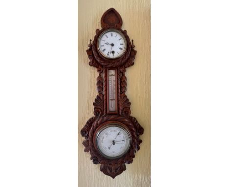 A carved oak aneroid barometer, mercurial thermometer and clock. Circa 1900. 66cm h x 27w. 