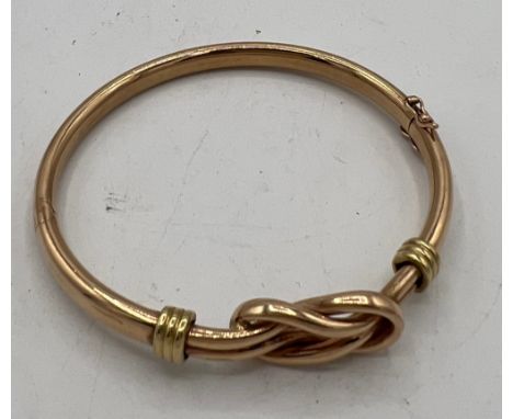 A 9 carat yellow gold bangle with knot decoration. Weight 12.1gm.&nbsp;67mm d.