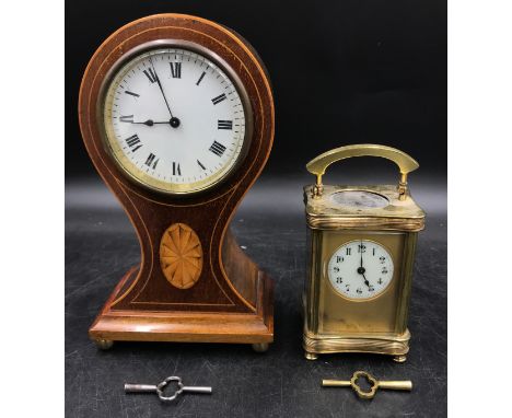 A mahogany inlayed balloon mantle clock on brass ball feet with circular white dial with roman numerals 24cm h along with a b