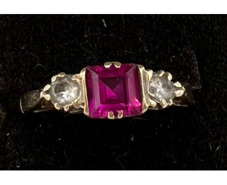 A 9 carat gold ring set with central synthetic ruby and synthetic white sapphires to each side. Size N. Weight 2.3gm. 