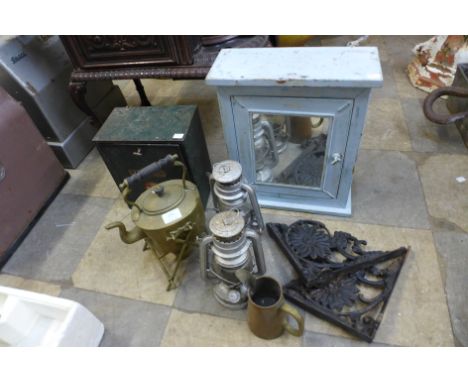 A vintage First Aid tin, mirrored wall cupboard, spirit kettle on stand, pair of wrought iron brackets, pair of paraffin lamp