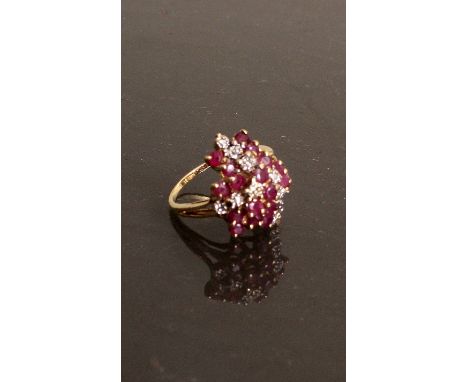 An American 14ct gold diamond and ruby cluster ring, the apparent random placed eighteen rubys divided by three rows of  diam