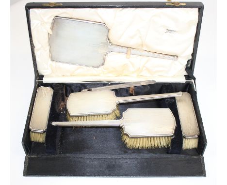 A silver backed six-piece dressing table set with engine turned decoration, in fitted case