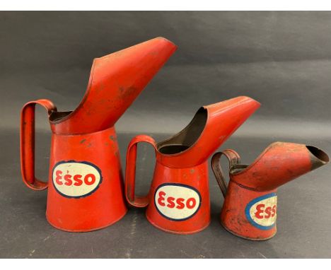 Three graduated Esso oil measures from quart to half pint.