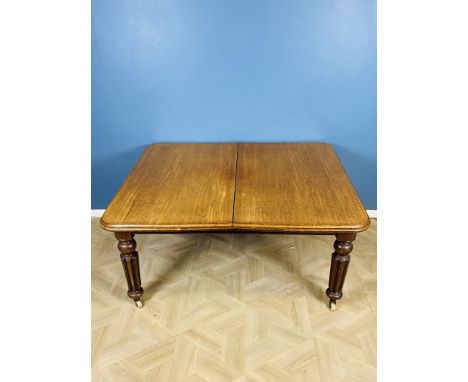 A Victorian mahogany rounded corner extending wind out dining room table with three additional leaves, raised upon turned and