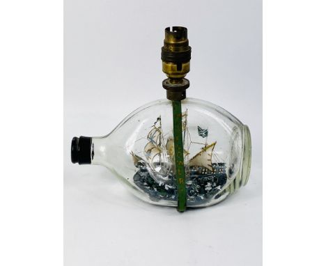 A shaped glass Mayflower ship in the bottle table lamp, 20cms wide x 13cms deep x 19.5cms high. Estimate £20-40.