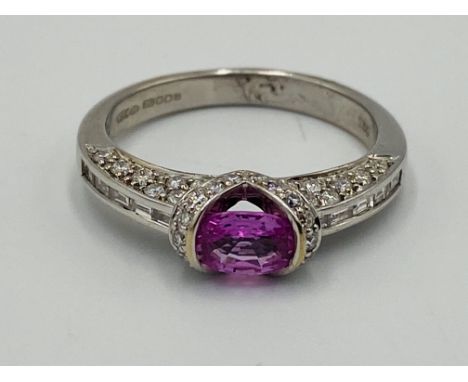 18ct white gold ring set with a pink sapphire with diamond shoulders and sides, size M. Estimate: £200-250