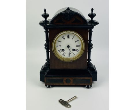 A decorative late 19th century continental 8-day mantle clock with an ebonised and inlaid case, enamelled dial with roman num