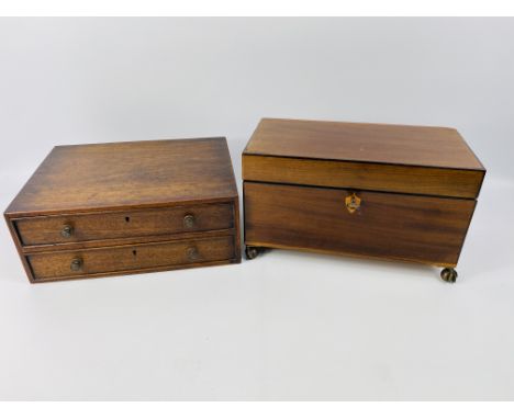 An early 19th century inlaid mahogany tea caddy with twin lidded interior tea canisters, brass lion mask side handles and rai