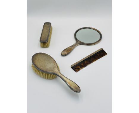 A silver dressing table set in fitted box, comprising two silver backed brushes, a silver backed mirror and silver backed com