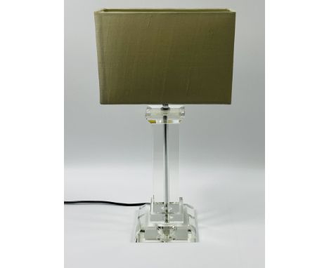 A contemporary glass table lamp with a square section column,and raised upon a stepped and bevelled base.14cm wide, 14cm deep