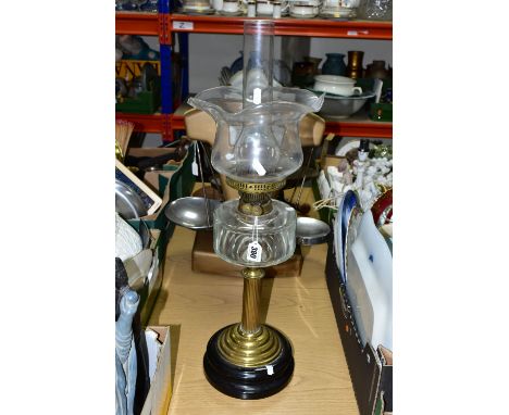 A TALL OIL LAMP, having a glass reservoir supported on a brass column and a black plinth style base, marked 'British Made', w