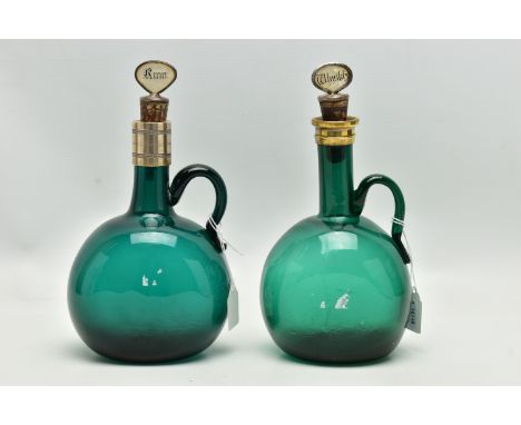 TWO VICTORIAN GREEN GLASS DECANTERS WITH METAL MOUNTS AND LOOP HANDLES, both with an ill-fitting mother and pearl and plated 