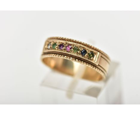 A 9CT YELLOW GOLD ACROSTIC RING, set with a row of circular cut gemstones spelling out the word 'Dearest', to a wide band wit