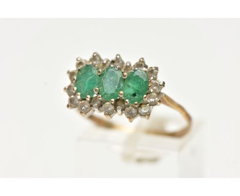 A 9CT GOLD, EMERALD AND DIAMOND CLUSTER RING, designed with three claw set, oval cut emeralds, in a surround of round brillia