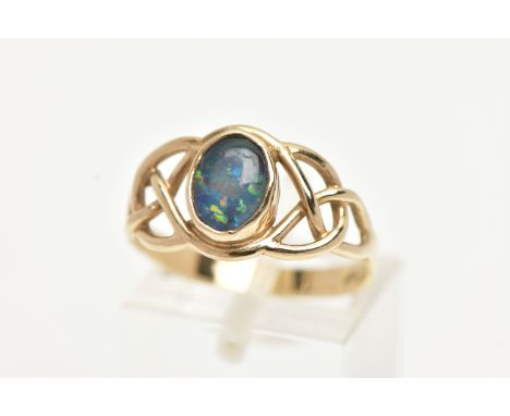 A YELLOW METAL GEMSET RING, a opal triplet collet set in an open work Celtic design yellow metal ring, stamped 9ct, ring size