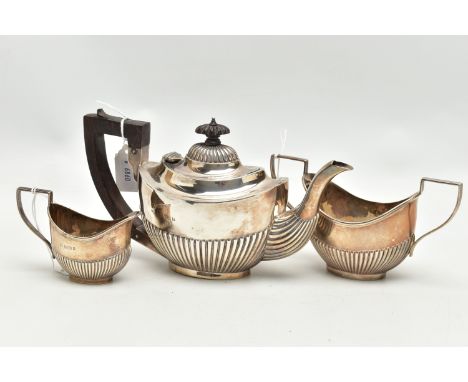 AN EDWARDIAN SILVER THREE PIECE BACHELOR'S TEA SET OF OVAL FORM, reeded decoration to the lower half, ebony fitments, makers 