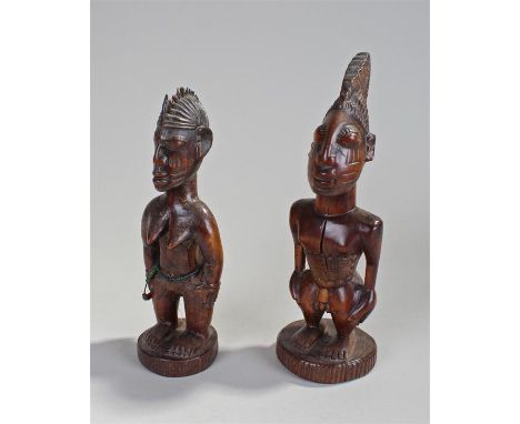 Two African figures, the first a female figure carved with geometric line body decoration, beads to the stomach and arm, 24cm