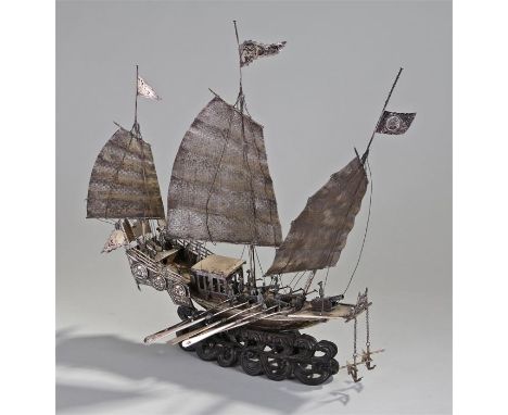 Chinese white metal Junk, with three sails, figures with canons on the deck, a row of five paddles to each side, raised on a 