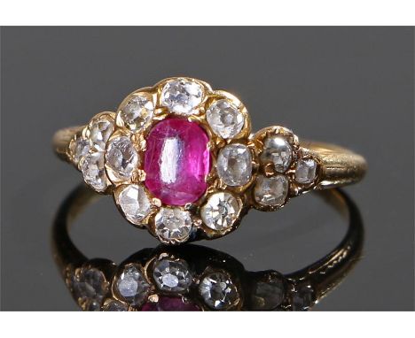 Yellow metal diamond and ruby ring, the central ruby surrounded with fourteen diamonds, ring size I 1/2