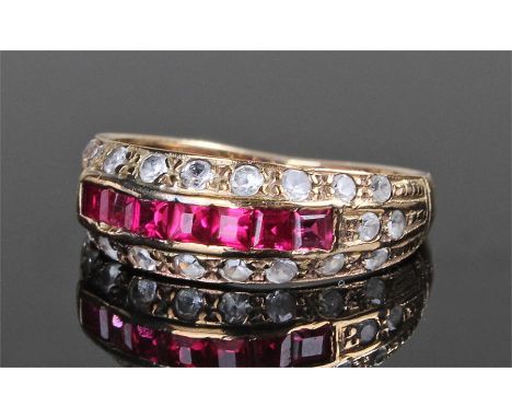 18 carat gold diamond and ruby set ring, with a row of eight emerald cut rubies, two rows of diamonds to either side, ring si