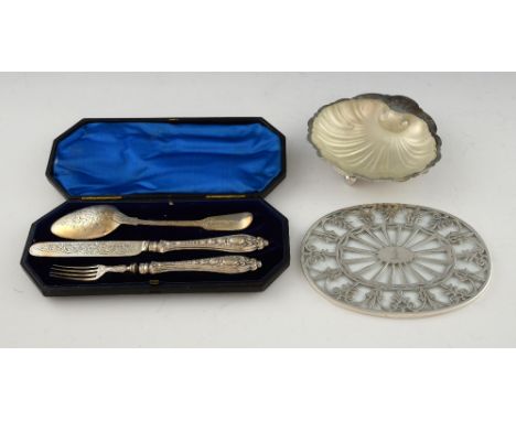 Silver shell butter dish with glass liner, a glass coaster with patterned silver mounts and a cased knife fork and spoon.    
