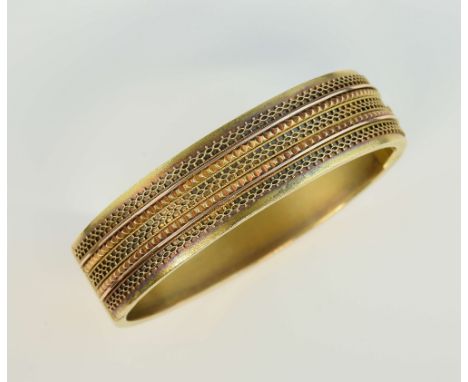 Victorian gold  hinged bangle, with wirework decoration, patinated in two colours, hidden clasp, unmarked gold testing as 15c