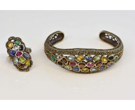 Multi stone set bangle, including rub over set oval cut rubies and paste stones, with scrolling cut out detail, mounted in si