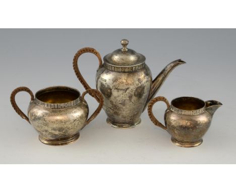 Victorian silver tea service for one, comprising tea pot, cream jug and sugar bowl with rattan handles, by James Deakin & Son