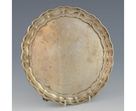 George V silver salver with serpentine border on three shaped scroll feet, by Gladwin Ltd., Sheffield, 1929, 19oz, 590g,.    