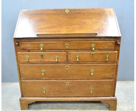 19th Century oak bureau the fall front with fitted interior above one drawer, two short and two long drawers to bracket base 